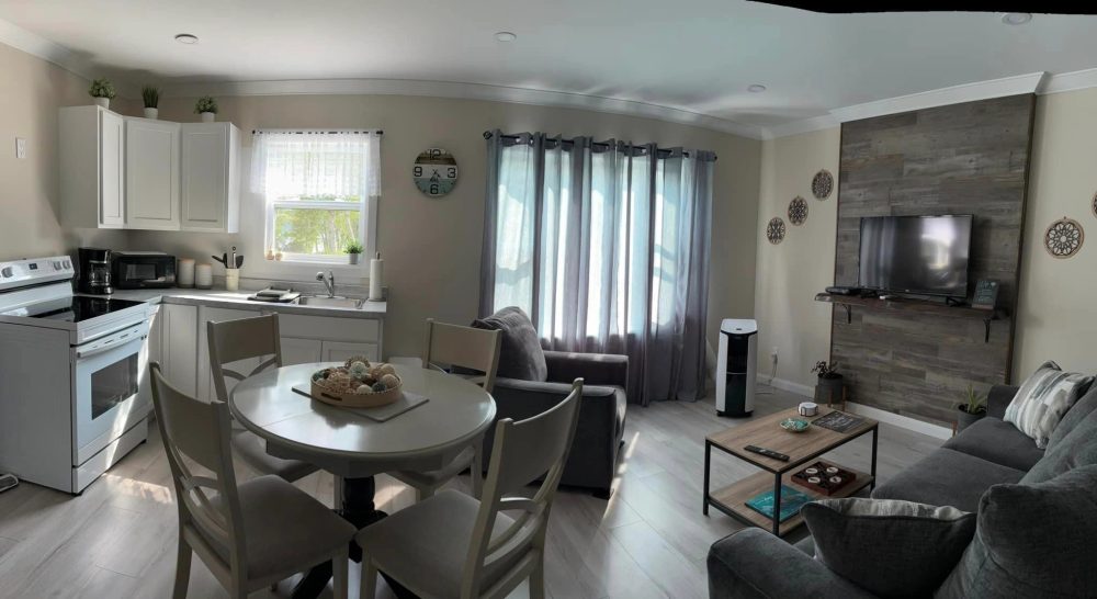 Unit B living room in neutral decor with warm touches of colour.